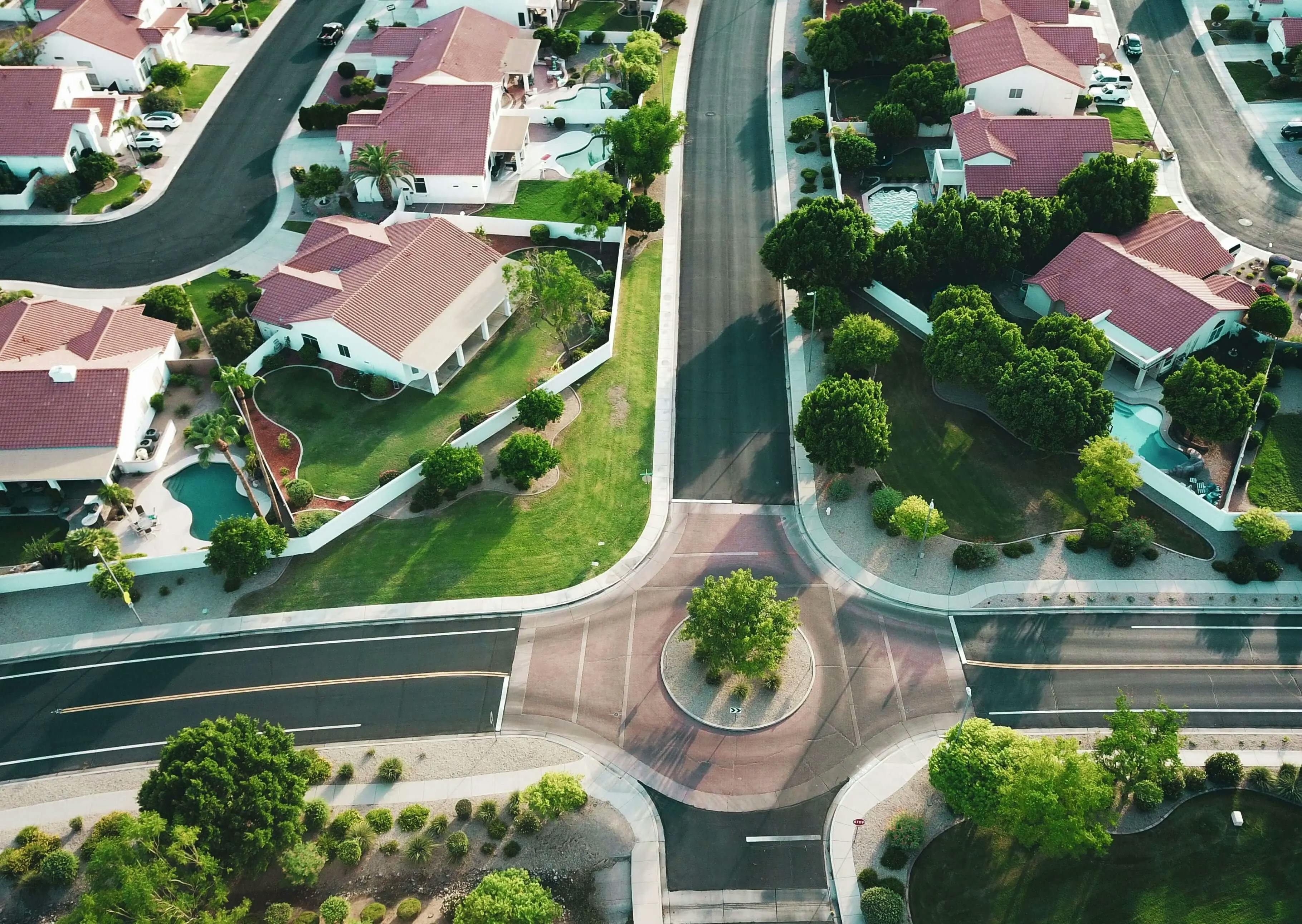 A bird's-eye view of a suburban community with houses, streets, and green spaces.
