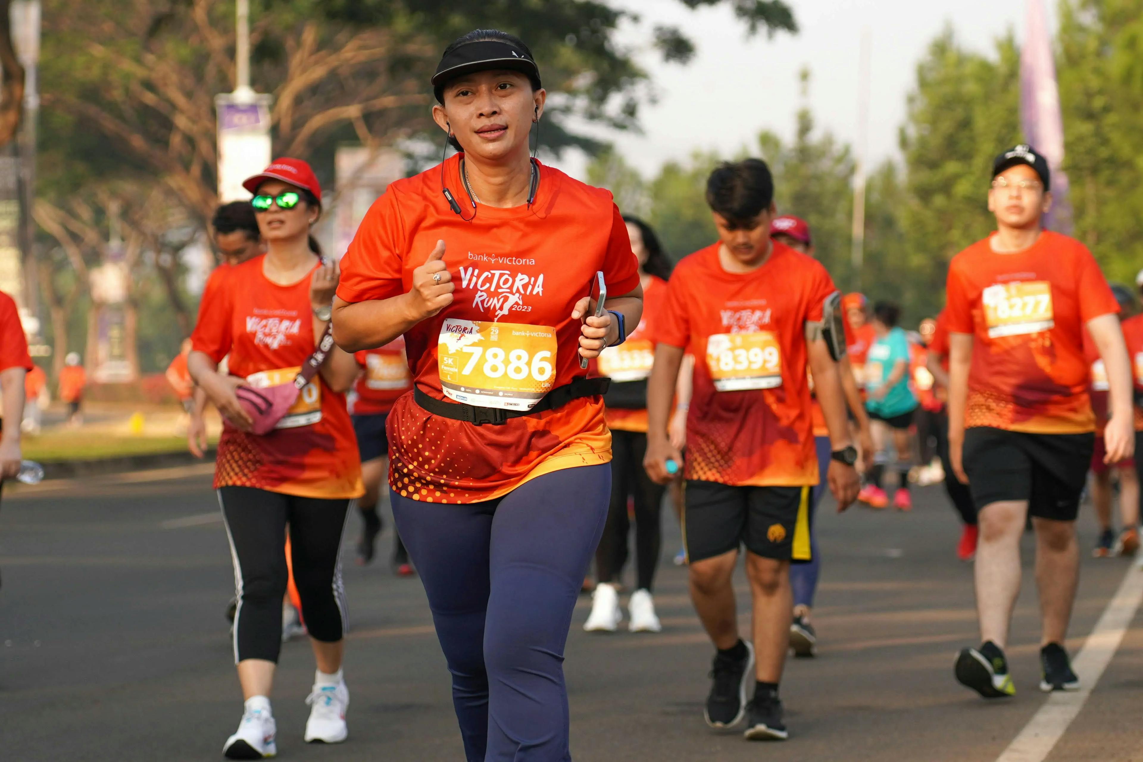 A group of people running together, wearing orange shirts.