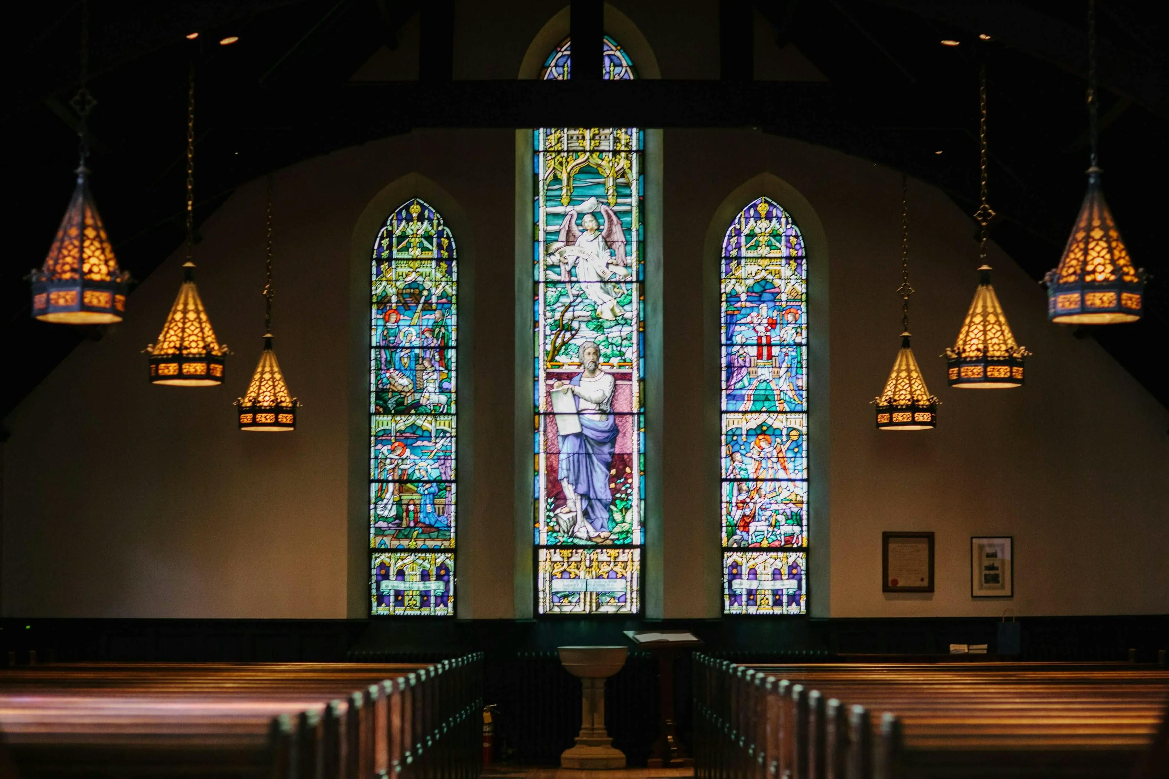 A church interior showcasing a beautiful stained glass window.